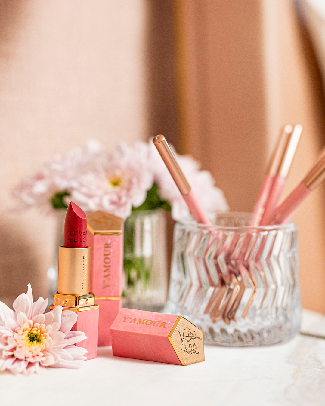 שפתון ימור עמיד בהקשר חיי יומיום, מוצג לצד פרחים ואביזרי איפור