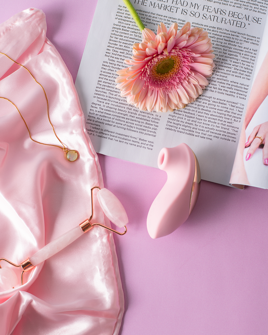 ויברטור יניקה ורוד בתמונת לייף סטייל, מוקף באביזרי טיפוח והרמוניה